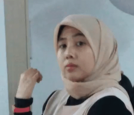 a woman in a hijab with her finger in her fist