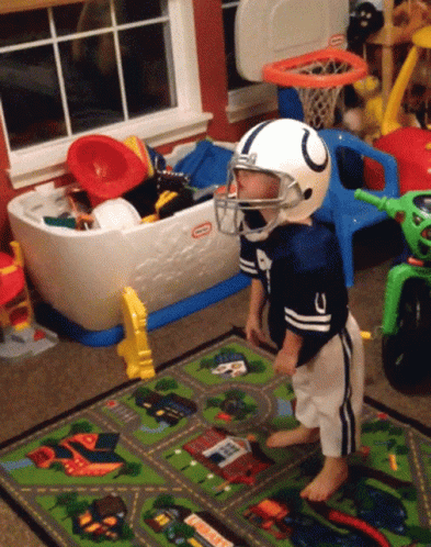 a football player stands near his toys in a bedroom