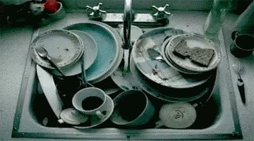 a kitchen sink full of dirty dishes and a knife