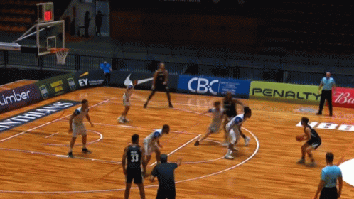 a group of people playing basketball in a gymnasium