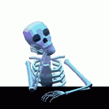 a skeleton sitting in front of a computer screen
