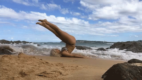 a person that is doing a hand stand on some rocks