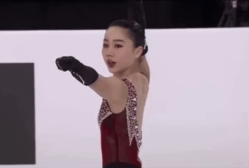 a figure skating on a ice rink making gestures