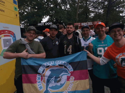 a group of men posing for the camera with a flag