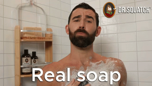 a bearded man is in the shower with no clothing on