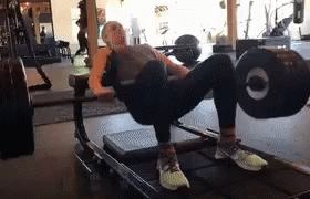 a woman is doing squats on a barbell