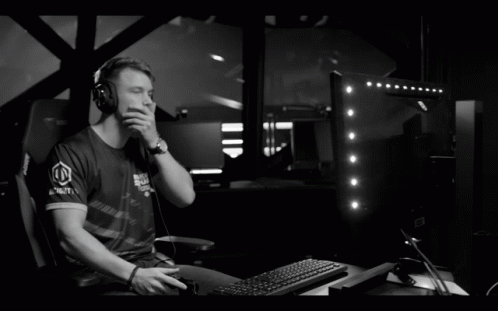 a man sits in front of a computer while talking on the phone