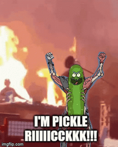 a cartoon character dressed up as a pickle stands on stage with arms raised