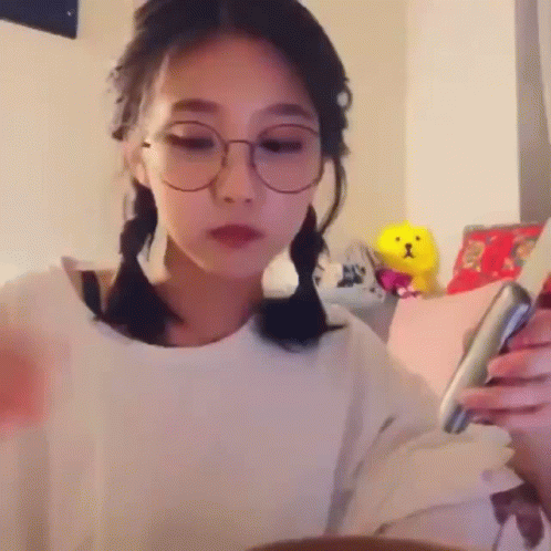 an image of a girl wearing glasses looking at her phone
