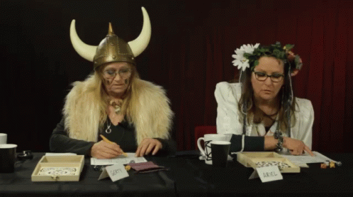 two people dressed as loki and loki in front of a table