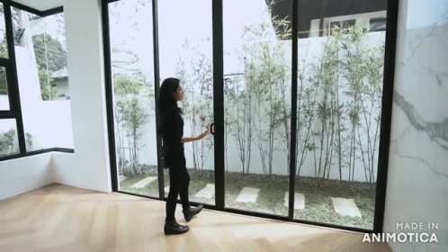 a person standing in a room with two windows