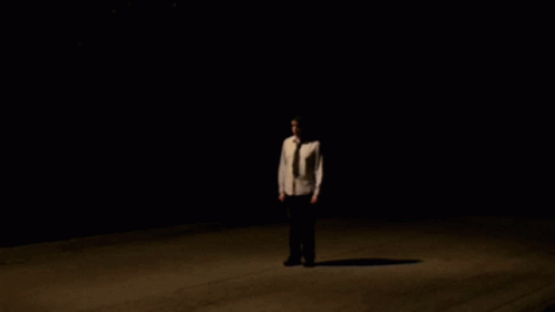 man standing alone in dark alone in the darkness