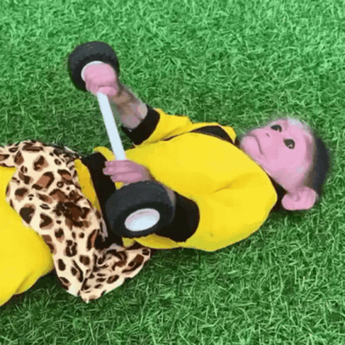 a  doll laying on the ground holding a bat