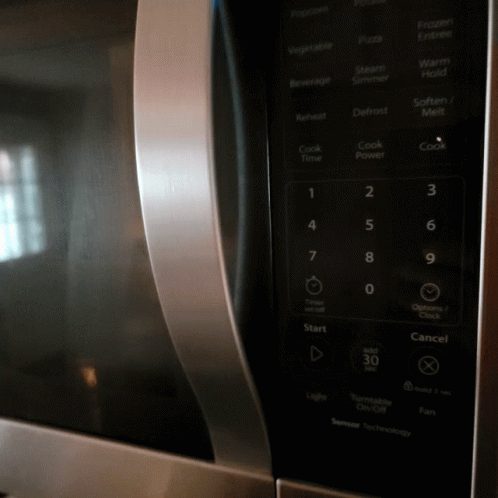 the top of a black microwave oven with ons on it