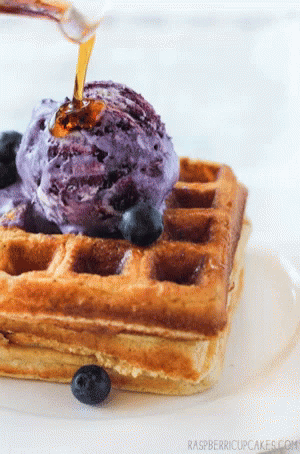 a purple ice cream sits atop a waffle
