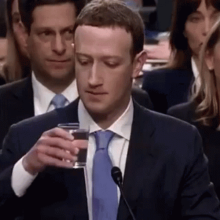 a man holding a glass in front of his face
