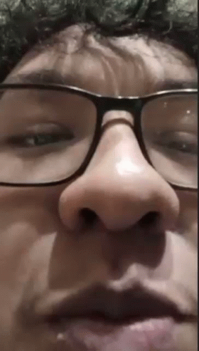 a man's nose and glasses are distorted to look like a creepy face