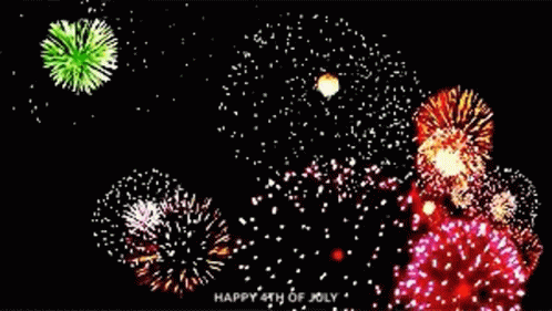 colorful fireworks, with white and blue ones, glow above a black night sky