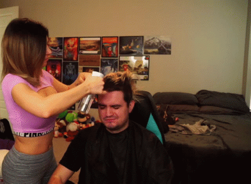 a woman blow dries her hair near another man