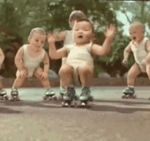 a couple of babies riding roller skates on the street