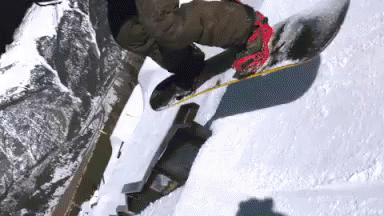 the snowboarder jumps his board as he does his stuff