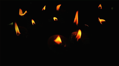 a black background with light blue flame in the dark