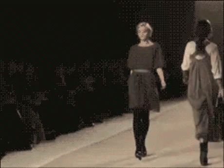 two people walking down the runway at a fashion show