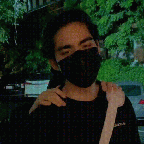 a woman wearing a face mask with her hands around her neck