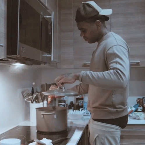 a man in the kitchen cooking some food