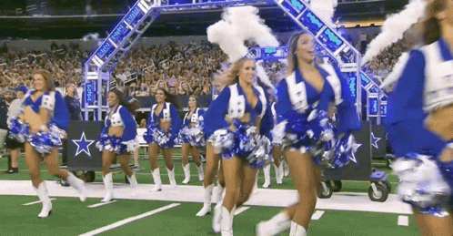 a large crowd is watching cheerleaders on a football field