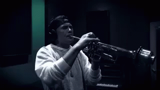 a man is playing a trumpet inside a recording studio