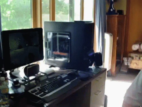 a view of an office with two monitors and a keyboard