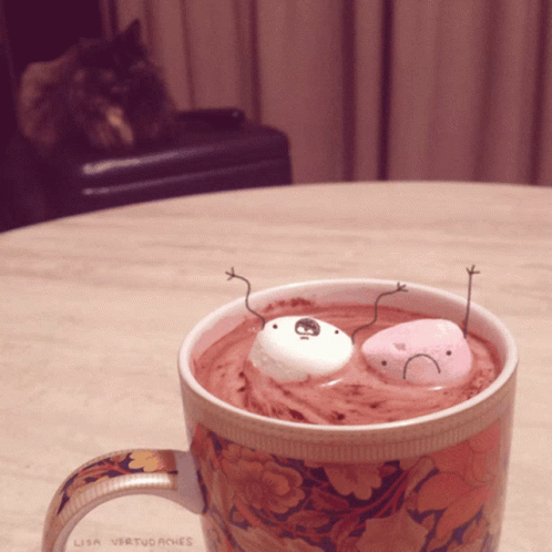 a cup filled with ice cream, fake googly eyes and a smiley face