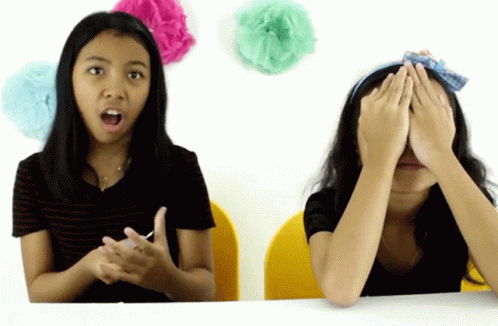 two girls covering their eyes and making funny faces