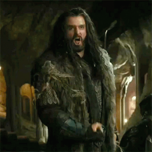 the hobbit character is holding his gun in one hand