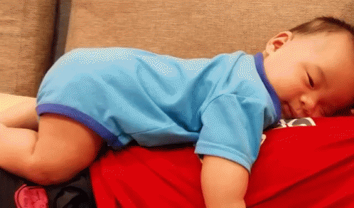 a small child sleeping on top of a blue couch