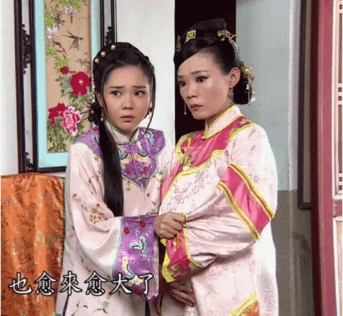 two asian women in traditional costumes posing for the camera