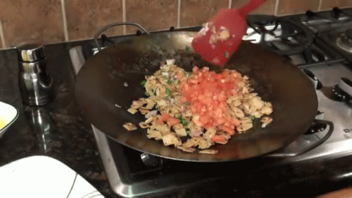 a frying pan on a stove with a flower arrangement inside
