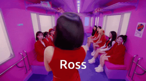 a girl sitting on some chairs looking down a corridor with text across the room that reads ross