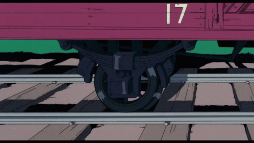 a purple and green train sitting on some tracks