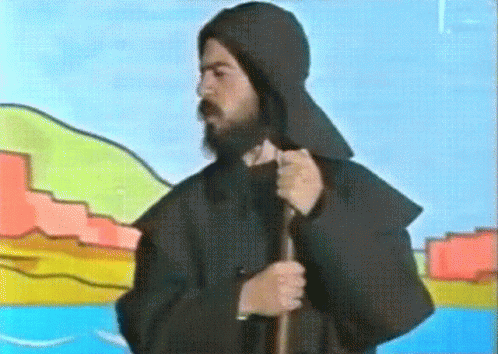 the image of a man with a beard wearing a hood and carrying a stick