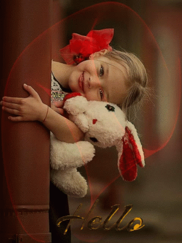 a little girl hugging a stuffed animal that is being held up by the arms