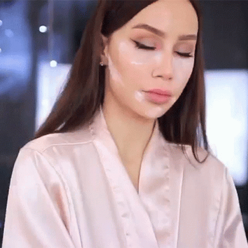 an asian woman wearing a white robe and makeup