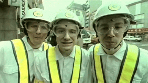 three men in hard hats wearing suspenders and safety gear