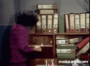 a woman is in a storage room picking files