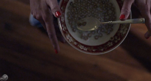 a woman wearing gloves holds a plate and a spoon