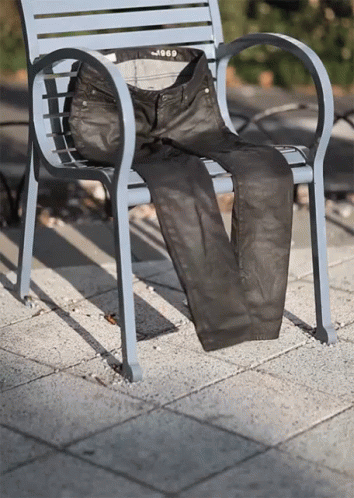 a chair sitting outside with a pants on the seat