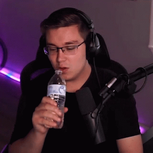 man wearing headphones drinking a bottle of water
