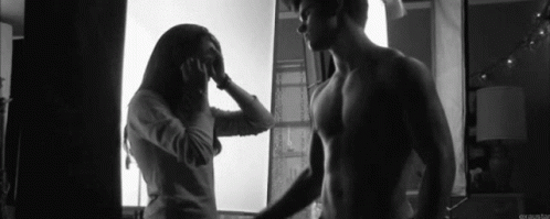 a man brushing his hair and a woman standing next to him