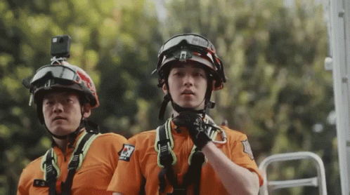 two men wearing helmets with harnesses and safety vests